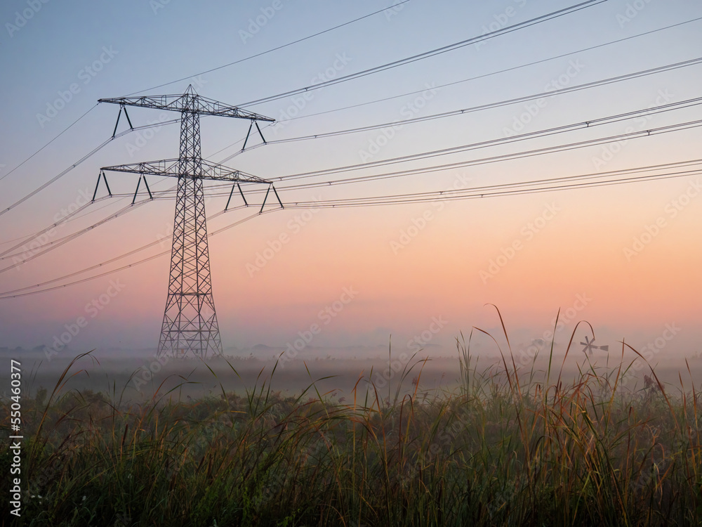 Three-phase electric power Transmission Lines in the morning fog on the moor near Amsterdam