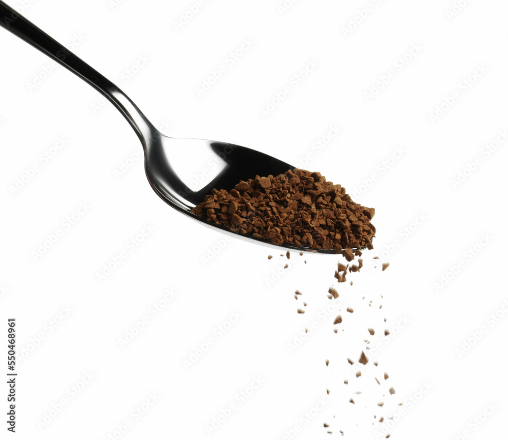 Pouring aromatic instant coffee from spoon on white background Pouring aromatic instant coffee from spoon on white background