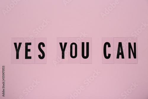 Phrase Yes You Can of plastic letters on pink background, top view. Motivational quote