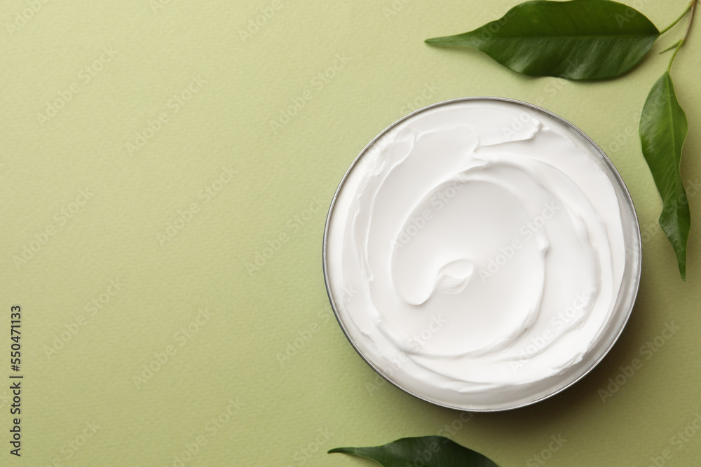 Jar of face cream and fresh leaves on light green background, flat lay. Space for text Jar of face cream and fresh leaves on light green background, flat lay. Space for text