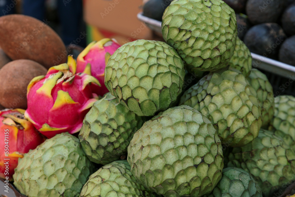 Fototapeta premium Cherimoya and dragon fruit at market, closeup