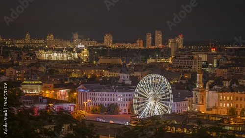 Aerial view of dusk Kyiv. Podil. Time-lapse of Square of Contracts and the Ferris wheel. National University of 