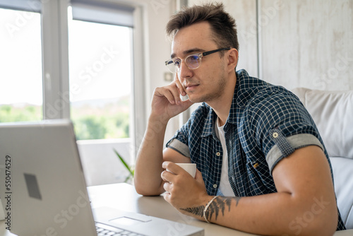 one man young adult caucasian male work on laptop computer in office