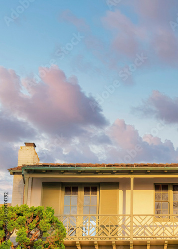 Vertical Puffy clouds at sunset Low angle view of a balcony with two double doors and shutters a