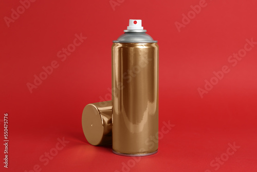 Golden can of spray paint on red background