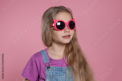 Girl in stylish sunglasses on pink background © New Africa