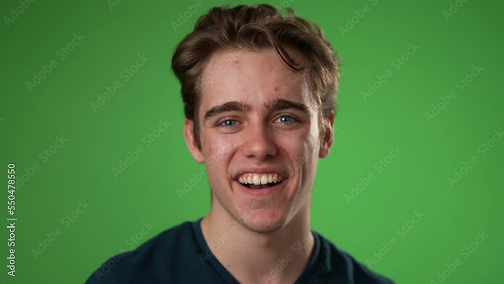 Closeup slow motion portrait of smiling happy young hipster man 20s isolated on green screen chroma key background with in studio Closeup slow motion portrait of smiling happy young hipster man 20s isolated on green screen chroma key background with in studio