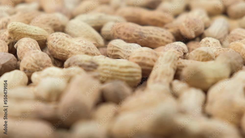 background of rotation of ground peanuts in the shell. ground peanuts rotates closeup. blurred foreground. slow motion. background of rotation of ground peanuts in the shell. ground peanuts rotates closeup. blurred foreground. slow motion.