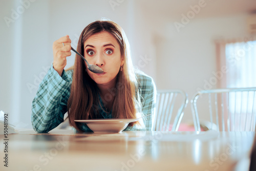 Funny Woman Eating Breakfast in the Kitchen . Girl having a snack all by herself in the living room
 photo