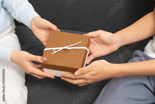 Close-Up of Young Couple Give Present Box for Anniversary, New Year, Celebrate Together. Hand exchange present box.