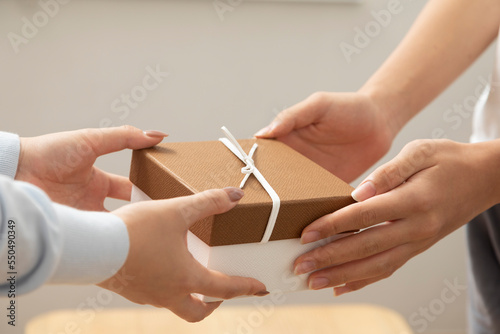 Close-Up of Young Couple Give Present Box for Anniversary  New Year  Celebrate Together. Hand exchange present box.