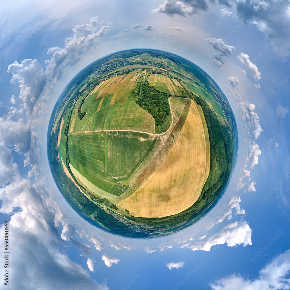 Fototapeta premium Aerial view from high altitude of little planet earth with green and yellow cultivated agricultural fields with growing crops on bright summer day