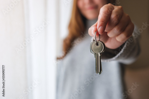 Blurred of a woman holding and showing the keys for real estate concept