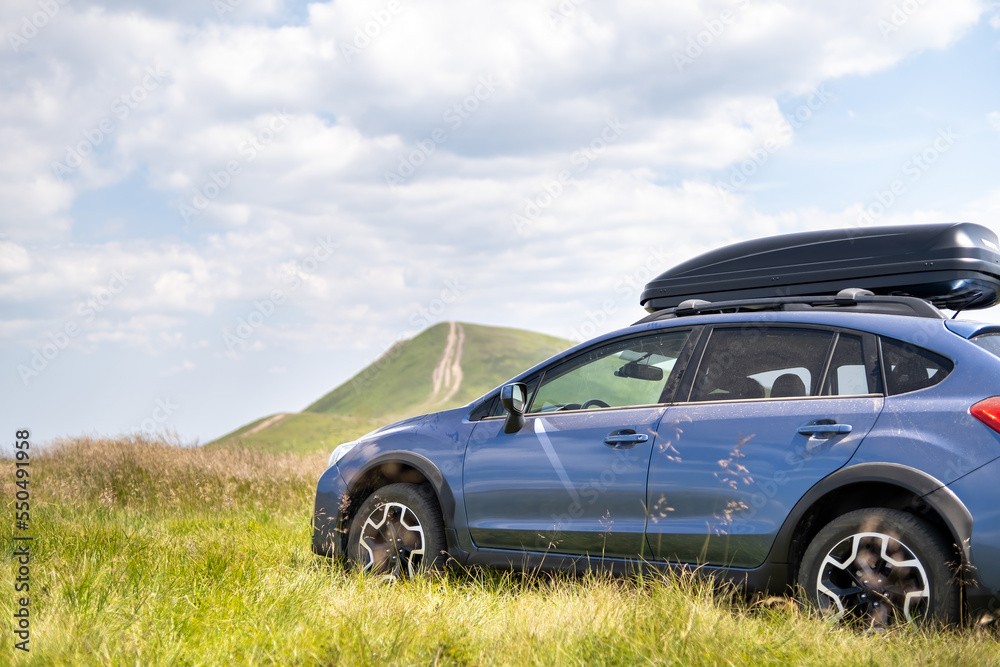 Blue off road car on mountain trail. Traveling by auto, adventure in wildlife, expedition or extreme travel on SUV automobile Blue off road car on mountain trail. Traveling by auto, adventure in wildlife, expedition or extreme travel on SUV automobile