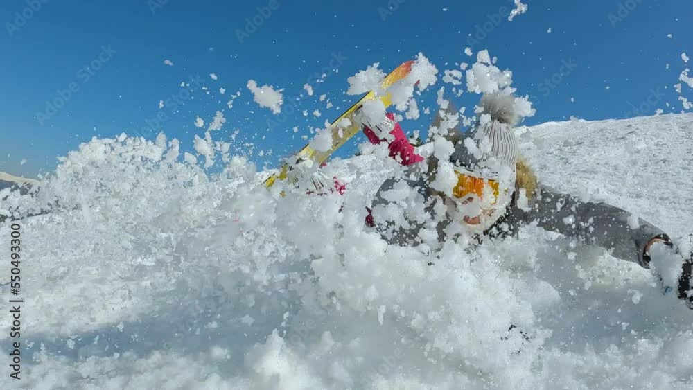 CLOSE UP: Lady trying to make a turn with snowboard when she crashes into snow. Female beginner snowboarder falls towards camera while she is learning to ride a snowboard on slope at snowy ski resort.