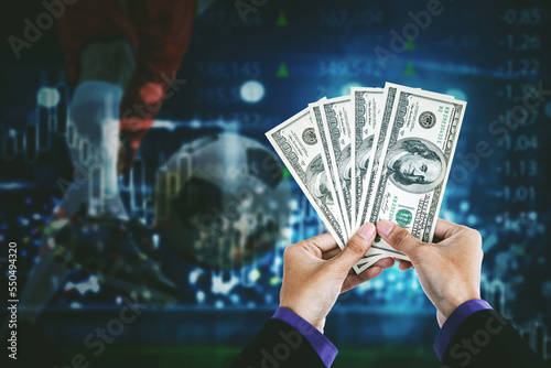 Businessman hands holding money with footballer