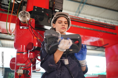 Robotics engineer working on maintenance of modern robotic arm in factory warehouse