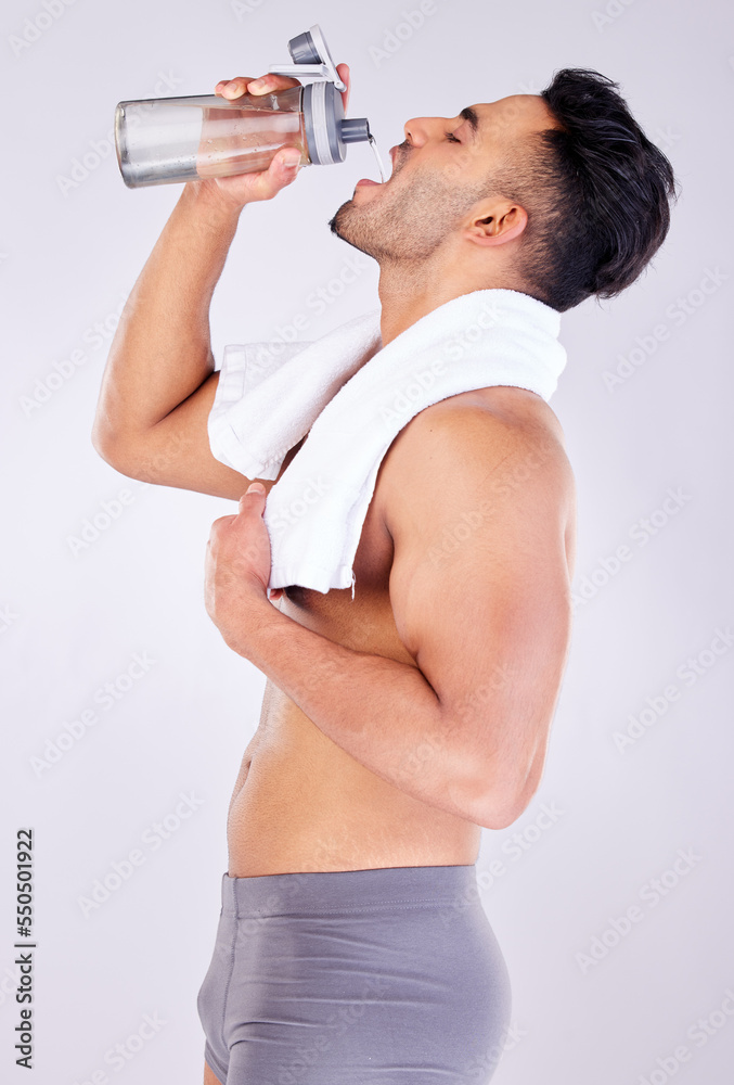Φωτογραφία Man drinking water with bottle, underwear and towel after gym workout or fitness training after shower
