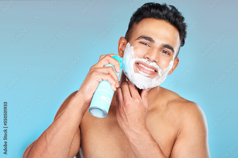 Skincare, face and man with shaving cream in studio on a blue background. Portrait, hair care or happy male model from Brazil spraying shave gel product for beard grooming, facial cleaning or hygiene