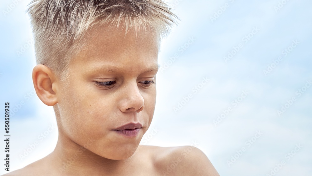 Boy with blue lips frozen from swimming in cold water at sea resort. Blond junior schoolboy gets cold after swimming against blue sky closeup Boy with blue lips frozen from swimming in cold water at sea resort. Blond junior schoolboy gets cold after swimming against blue sky closeup