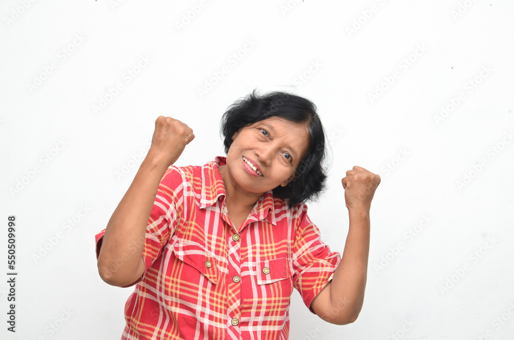 Portrait of happy ecstatic senior asian woman making yes winning gesture with raising her fist isolated over white Portrait of happy ecstatic senior asian woman making yes winning gesture with raising her fist isolated over white