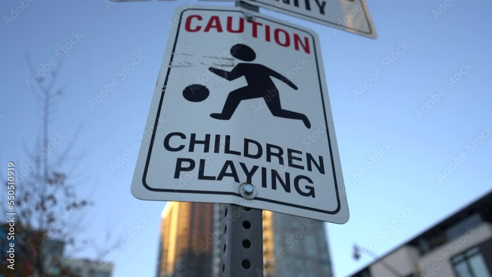Close up pan of Caution, Children Playing sign near park in neighbourhood
