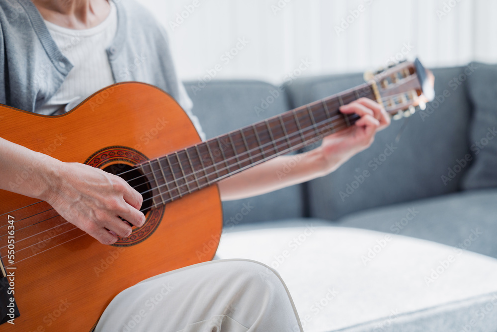 ギターを演奏するシニアの女性
