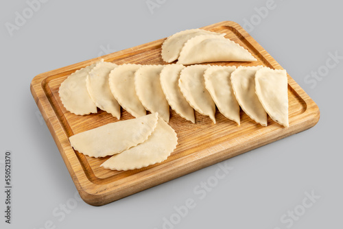 Wallpaper Mural Homemade raw dumplings with potatoes on a wooden board on a light gray background. Cooking dumplings with mashed potatoes Torontodigital.ca