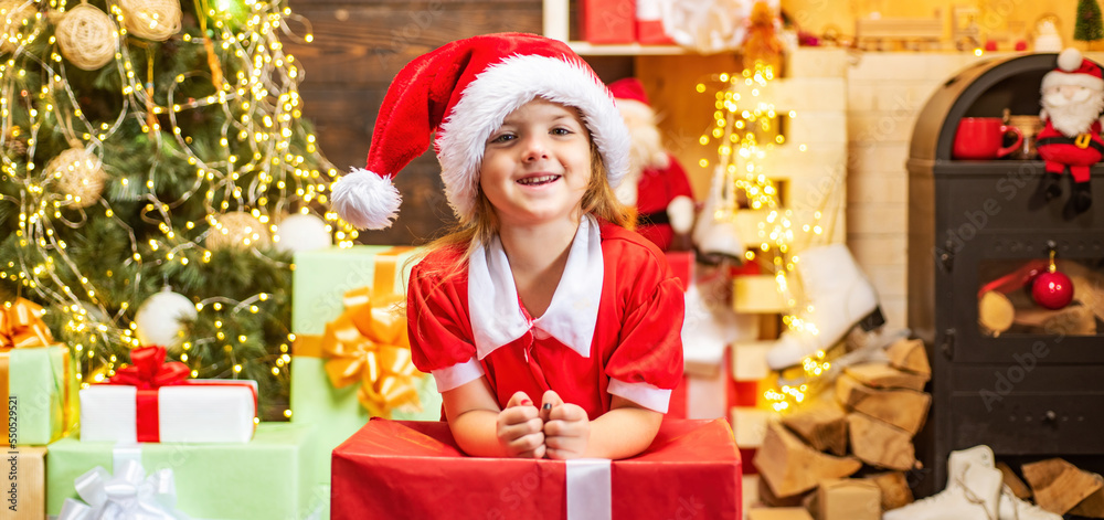 Cute little kids celebrating Christmas. Christmas kids celebration holiday. Happy cute child in Santa hat with present have a Christmas.