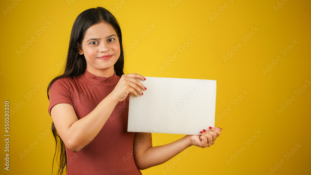 Beautiful young woman holding empty blank white board, your text here concept, Asian Indian girl isolated over colour background studio Beautiful young woman holding empty blank white board, your text here concept, Asian Indian girl isolated over colour background studio