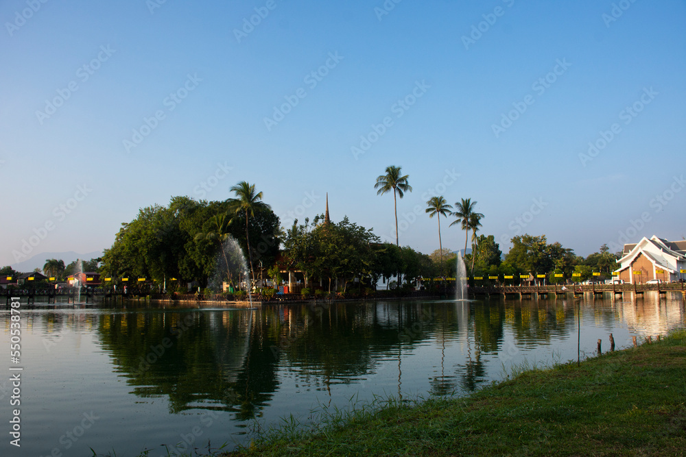 View landscape water pond garden park and Wat Traphang Thong on island with cityscape old town for thai people foreign travelers travel visit in morning time at Sukhothai Historical Park in Thailand