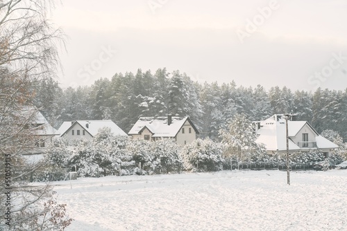 Residential house in the winter. A dwelling cottage in a rural is covered with freshly fallen snow.