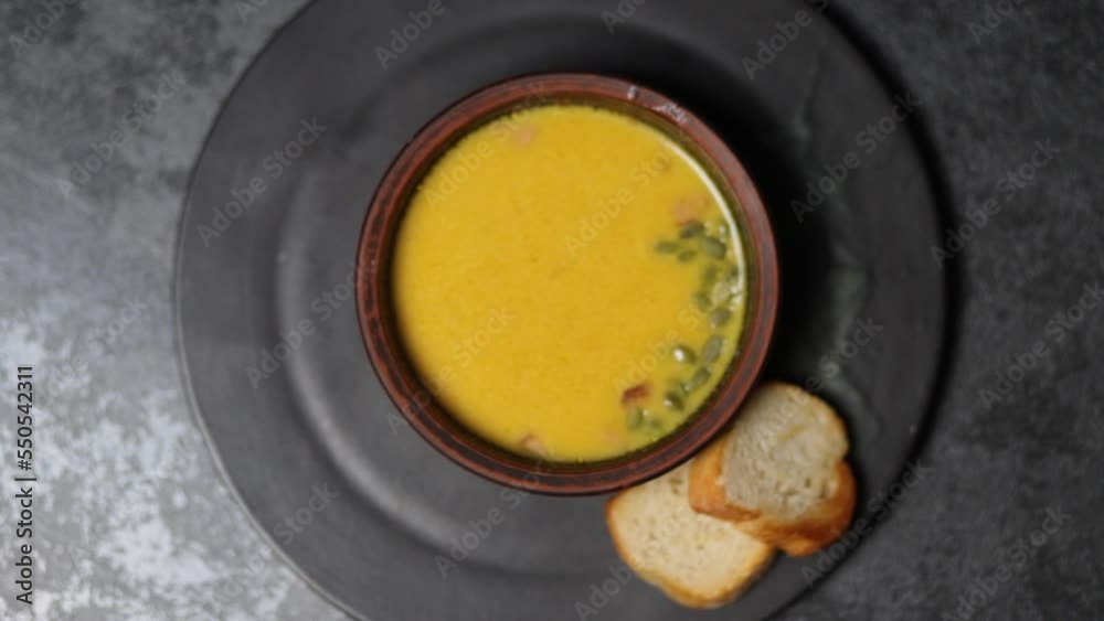 A plate of vegetable pumpkin soup. Gradual focusing. Top view on a black background. A plate of vegetable pumpkin soup. Gradual focusing. Top view on a black background.