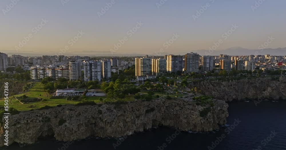 Antalya Turkey Aerial v18 cinematic pull out away from clifftop urban park capturing coastal cityscape of fener residential neighborhood at sunset golden hour - Shot with Mavic 3 Cine - July 2022 Antalya Turkey Aerial v18 cinematic pull out away from clifftop urban park capturing coastal cityscape of fener residential neighborhood at sunset golden hour - Shot with Mavic 3 Cine - July 2022