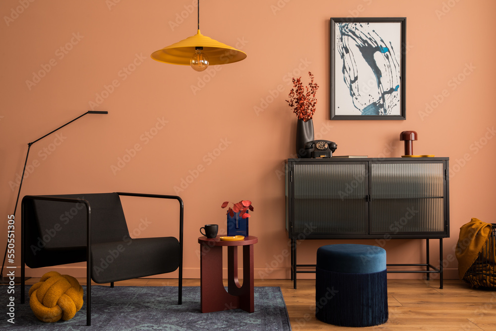 Interior design of cozy living room with mock up poster frame, glass sideboard, yellow lamp, navy pouf, carpet, black armchair, vase with dried flowers and personal accessories. Home decor. Template. Interior design of cozy living room with mock up poster frame, glass sideboard, yellow lamp, navy pouf, carpet, black armchair, vase with dried flowers and personal accessories. Home decor. Template.