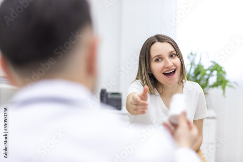 Photo of pregnant woman with open mouth reaching out to doctor.