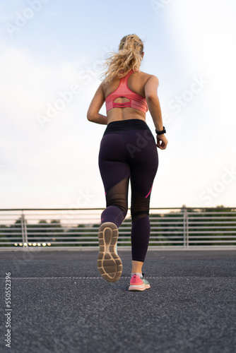 vertical photo of Rear view of a girl running in the city