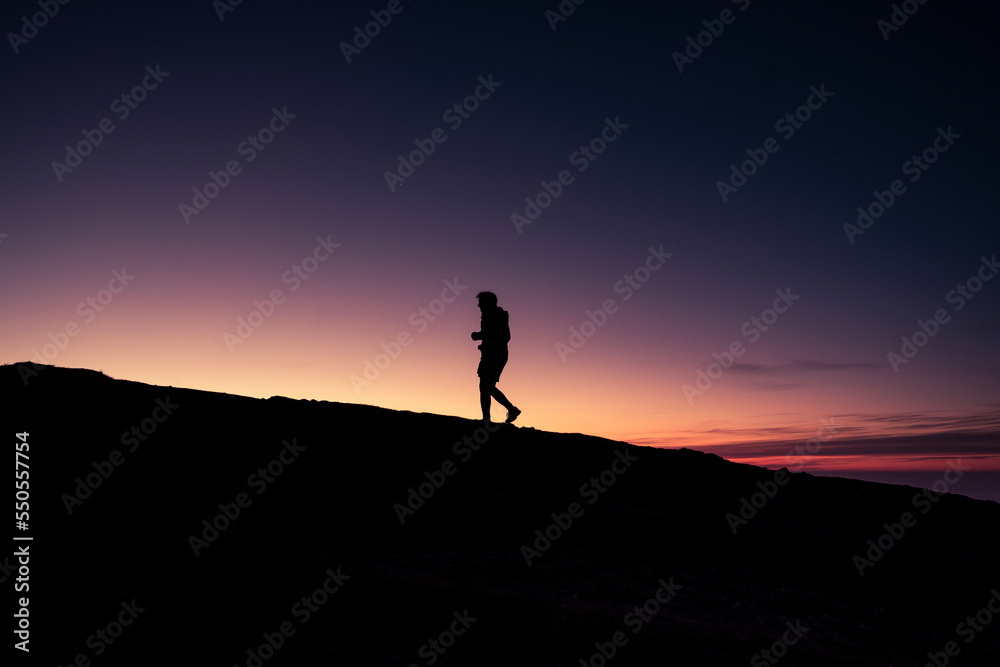 silhouette of a person on a mountain top
