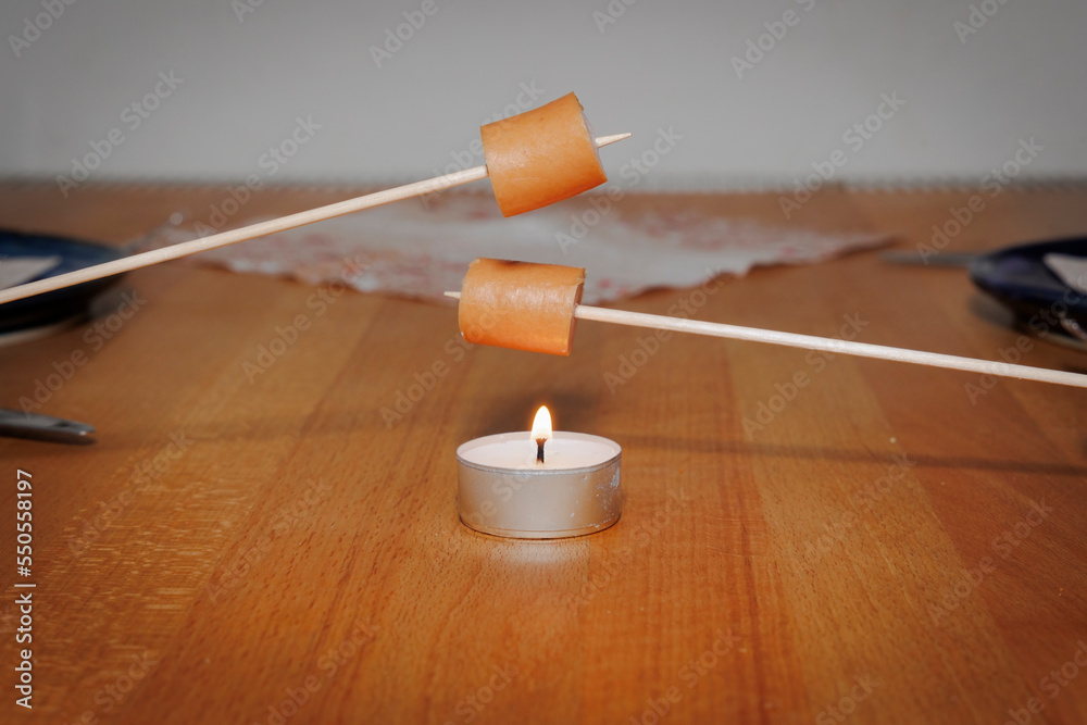 minimal Barbecue party with two toothpickers and sausage over a candlelight minimal Barbecue party with two toothpickers and sausage over a candlelight