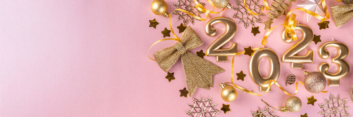New year 2023 celebration greeting card background Gold numbers 2023 with golden party decoration, stars confetti on pink background. Flat lay, Merry Christmas, Noel happy New Year holidays banner