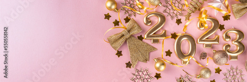 Canvas Print New year 2023 celebration greeting card background Gold numbers 2023 with golden party decoration, stars confetti on pink background