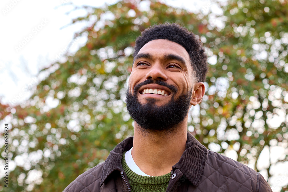 Smiling Young Man Wearing Coat Standing Outside In Autumn Or Winter Countryside Smiling Young Man Wearing Coat Standing Outside In Autumn Or Winter Countryside