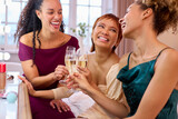 Group Of Female Friends At Home Dressed Up And Drinking Champagne Before Night Out