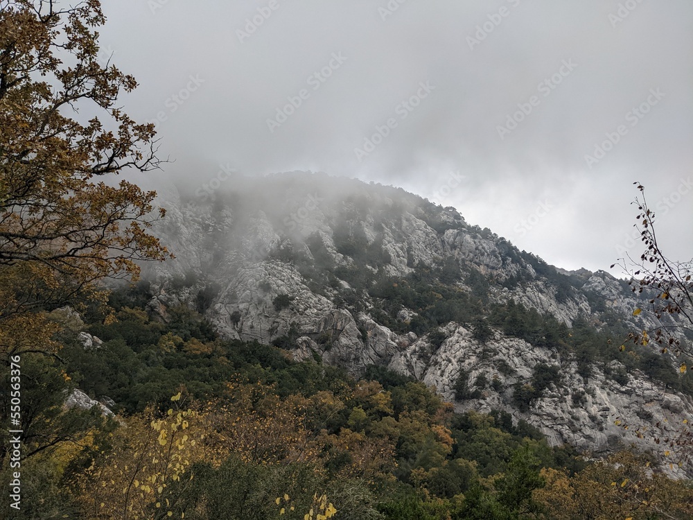 Autumn in the mountains. Clouds roll over the rocks. Mysterious atmosphere