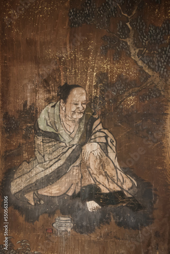 Buddhist monk painting in a wood wall in japan