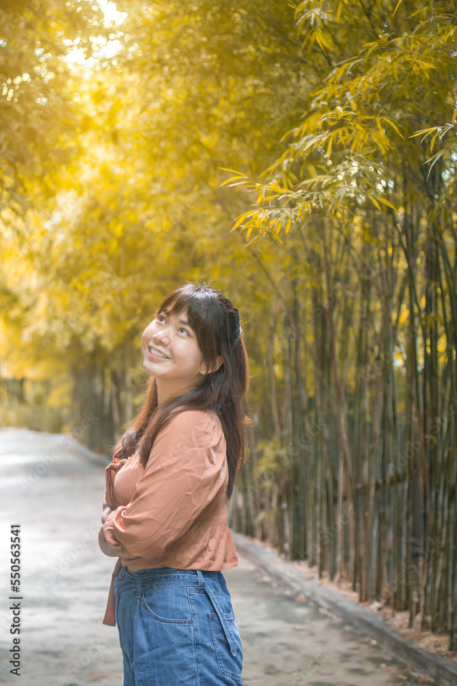 Happy Asian woman standing happily in bamboo garden Happy Asian woman standing happily in bamboo garden