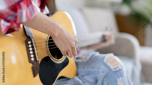 Close up fingers playing guitar strings, Strum to make a sound, Acoustic guitar, Catching guitar chords to create music, Music therapy and meditation practice with playing the guitar.