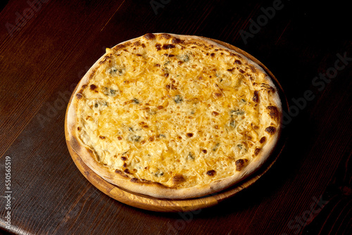 Italian pizza four cheeses on a wooden board. Italian cuisine. Close-up