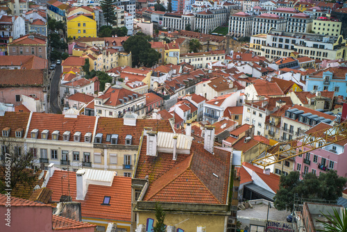 historic buildings of the old town of lisbon. Old colorful buildings, narrow streets, historic churches. Tiled roofs. View from the top of the tenement houses and monuments. Cloudy day 