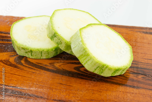 sliced fresh green cucumber on wooden cutting board